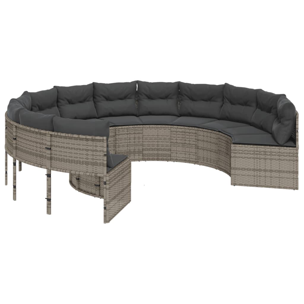 Pilka apvali sodo sofa su stalu ir pagalvėlėmis